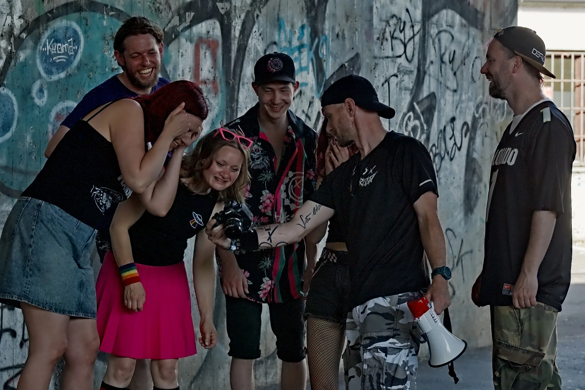 Die Baxxter Boys schauen lachend auf ein Kameradisplay